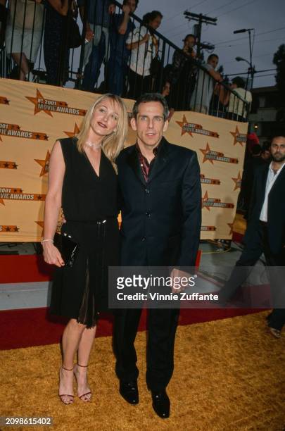 American actress Christine Taylor, wearing a sleeveless black v-neck dress, and her husband, American actor and comedian Ben Stiller, who wears a...