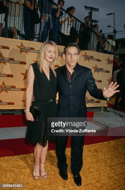 American actress Christine Taylor, wearing a sleeveless black v-neck dress, and her husband, American actor and comedian Ben Stiller, who wears a...
