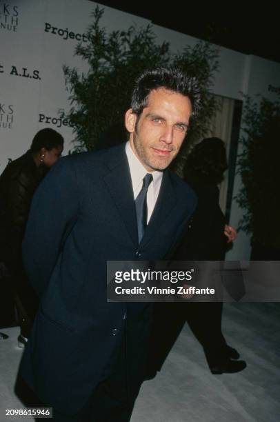 American actor and comedian Ben Stiller, wearing a black suit over a white shirt with a black tie, attends the inaugural Los Angeles Benefit for...