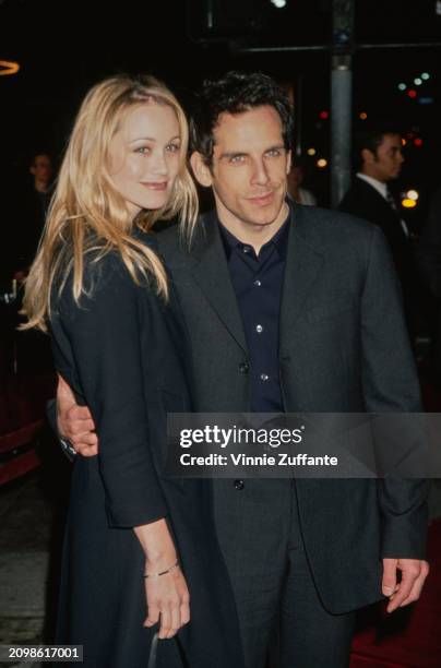 American actress Christine Taylor, wearing a black coat, and her husband, American actor and comedian Ben Stiller, who wears a black suit, attend the...