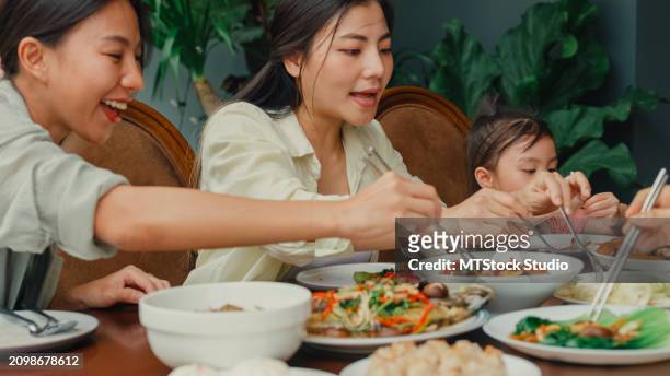young asian family eating chinese food and having fun sitting at dining table at backyard outside home. multi-generation family enjoying spending together. - chinese eating backyard stock pictures, royalty-free photos & images