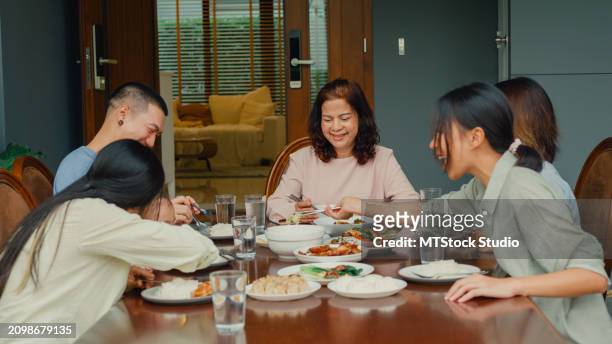 asian family eating chinese food and having fun sitting at dining table at backyard outside home. multi-generation family enjoying spending together. - chinese eating backyard stock pictures, royalty-free photos & images