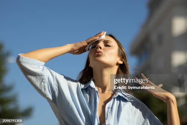 woman drying sweat in a warm summer day - high forehead stock pictures, royalty-free photos & images
