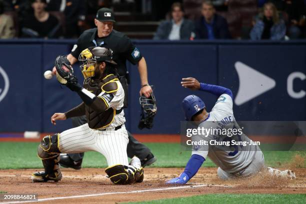 Teoscar Hernandez of the Los Angeles Dodgers slides safely into the home plate to score a run by a sacrifice fly of Jason Heyward in the 4th inning...