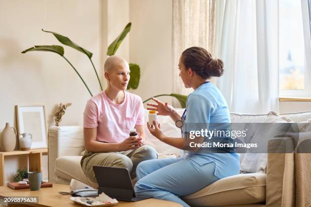 female nurse discussing with female cancer patient over medicine - oncologist stock pictures, royalty-free photos & images