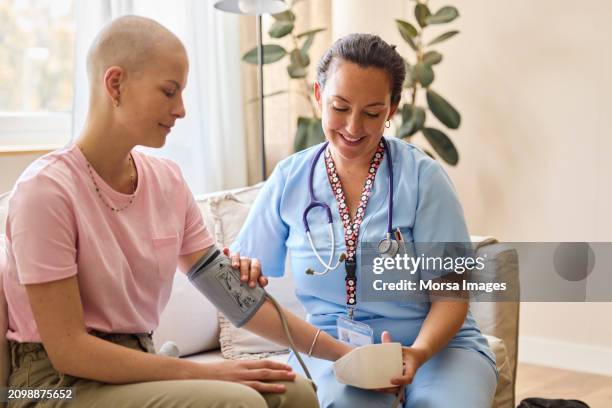 nurse examining female cancer patient at home - cancer bildbanksfoton och bilder
