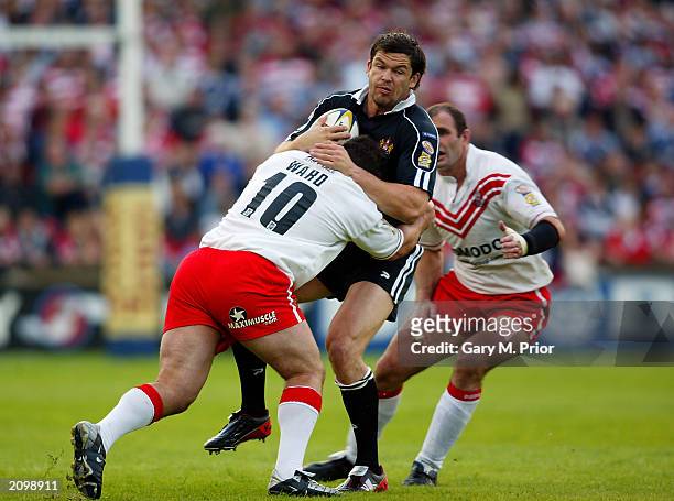 Andy Farrell of Wigan Warriors is tackled by Barry Ward of St Helens during the Tetleys Super League match between St Helens and Wigan Warriors held...