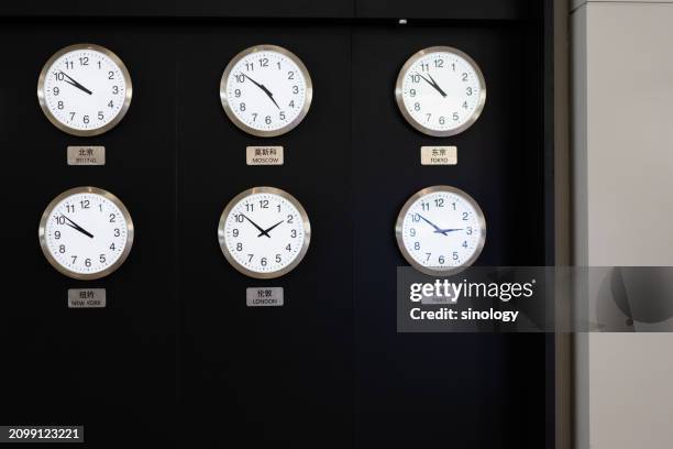 world time clock wall in airport - zona horaria fotografías e imágenes de stock