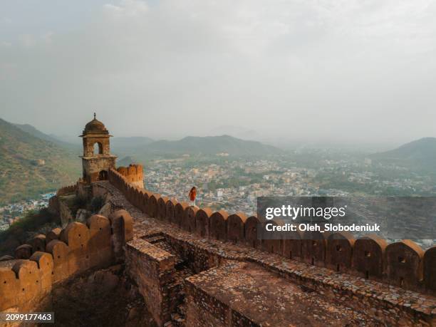 mujer caminando sobre la pared circundante en amber, jaipur - rajastán fotografías e imágenes de stock