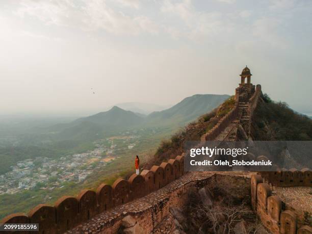 woman walking on surrounding wall in amber, jaipur - jaipur city view stock pictures, royalty-free photos & images