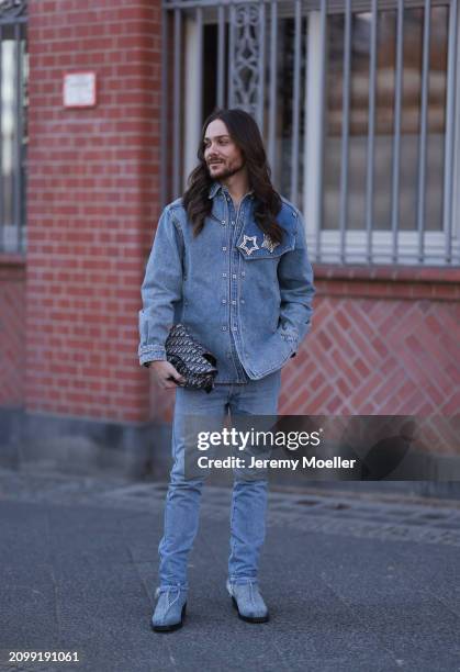 Riccardo Simonetti seen wearing Y Project blue denim jacket with rhinestone pattern star brooches, Levi’s blue denim straight leg pants / jeans,...