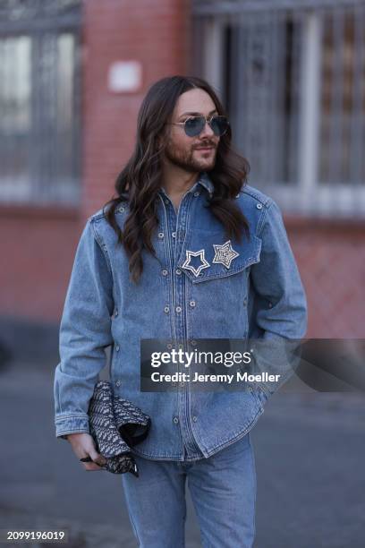 Riccardo Simonetti seen wearing gold sunglasses with blue lenses, Y Project blue denim jacket with rhinestone pattern star shaped brooches, Levi’s...