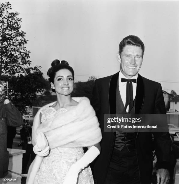 American baseball player and actor Chuck Connors and his wife, Kamala Devi, arrive at actor Glenn Ford's wedding to actor Kathryn Hays, 1966.