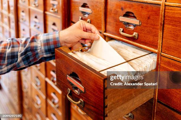person flipping through files of indexed cards at the library - ordre alphabétique photos et images de collection