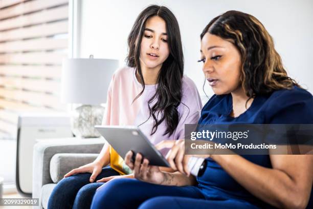 female doctor discussing supplements with teenage girl in medical office - daily life in multicultural birmingham stock pictures, royalty-free photos & images