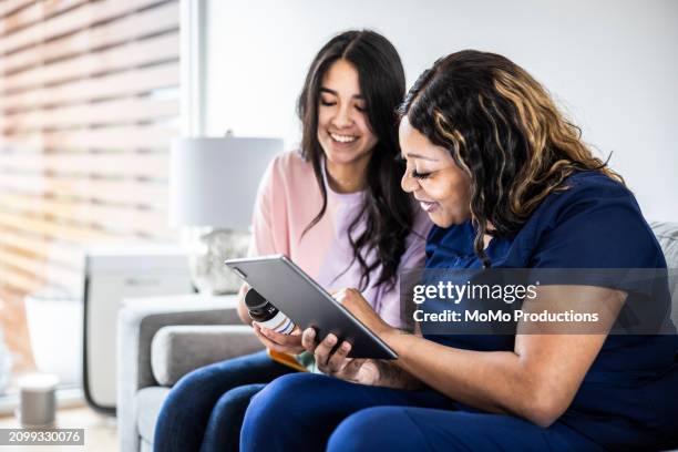 female doctor discussing supplements with teenage girl in medical office - daily life in multicultural birmingham stock pictures, royalty-free photos & images