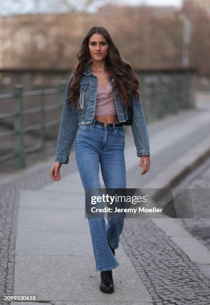 Michelle Golke seen wearing gold necklace, light pink lace crop top, blue denim cropped denim jacket, matching blue denim wide leg pants / jeans,...