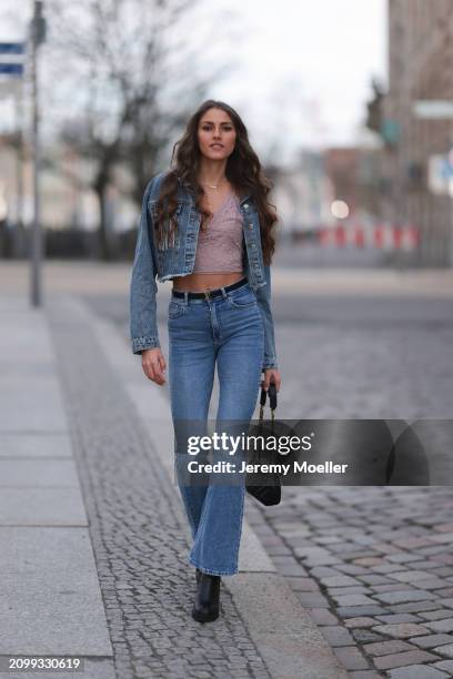 Michelle Golke seen wearing gold necklace, light pink lace crop top, blue denim cropped denim jacket, matching blue denim wide leg pants / jeans,...