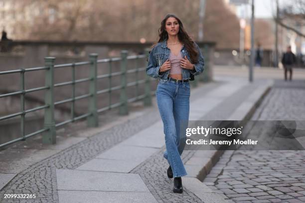 Michelle Golke seen wearing gold necklace, light pink lace crop top, blue denim cropped denim jacket, matching blue denim wide leg pants / jeans,...