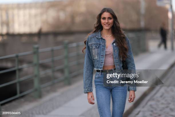 Michelle Golke seen wearing gold necklace, light pink lace crop top, blue denim cropped denim jacket, matching blue denim wide leg pants / jeans,...