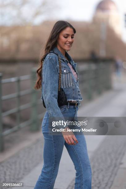 Michelle Golke seen wearing gold necklace, light pink lace crop top, blue denim cropped denim jacket, matching blue denim wide leg pants / jeans,...