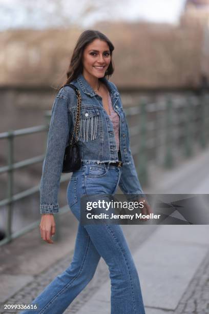 Michelle Golke seen wearing gold necklace, light pink lace crop top, blue denim cropped denim jacket, matching blue denim wide leg pants / jeans,...