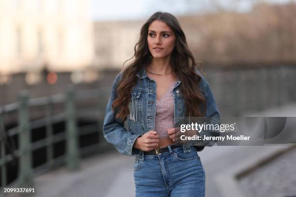 Michelle Golke seen wearing gold necklace, light pink lace crop top, blue denim cropped denim jacket, matching blue denim wide leg pants / jeans,...