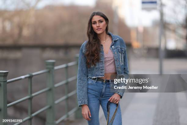 Michelle Golke seen wearing gold necklace, light pink lace crop top, blue denim cropped denim jacket, matching blue denim wide leg pants / jeans,...