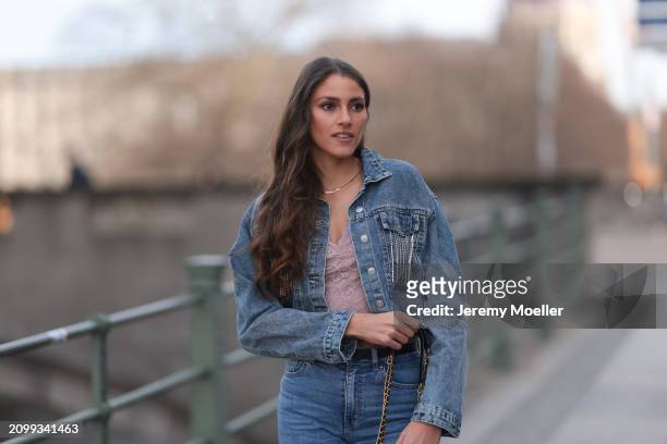 Michelle Golke seen wearing gold necklace, light pink lace crop top, blue denim cropped denim jacket, matching blue denim wide leg pants / jeans,...