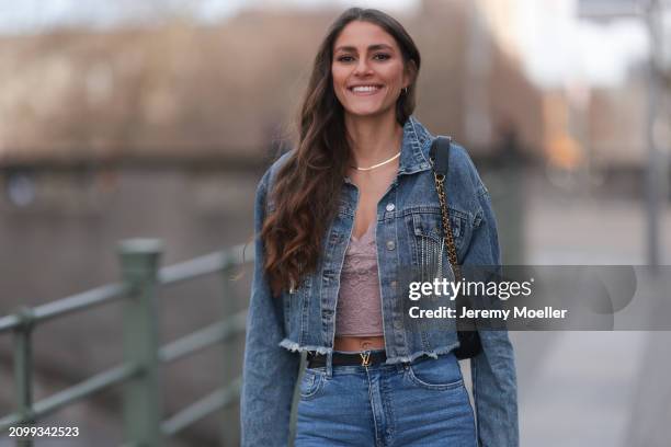 Michelle Golke seen wearing gold necklace, light pink lace crop top, blue denim cropped denim jacket, matching blue denim wide leg pants / jeans,...