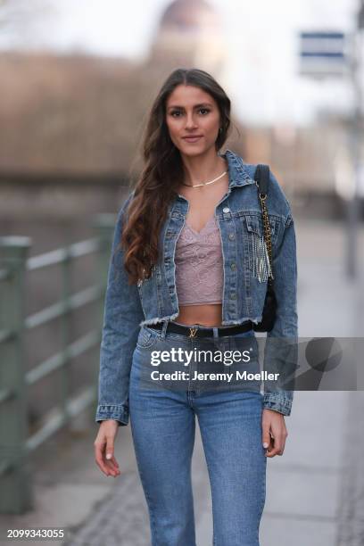 Michelle Golke seen wearing gold necklace, light pink lace crop top, blue denim cropped denim jacket, matching blue denim wide leg pants / jeans,...