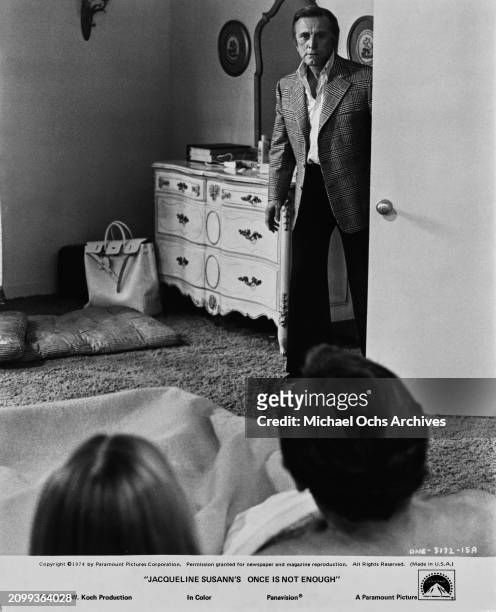 American actor and film director Kirk Douglas walks in on American actress Deborah Raffin and American actor David Janssen in bed together, in a...
