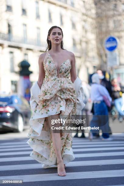 Valentina Ferragni wears a sleeveless asymmetric ruffled floral dress with a deep neckline, high heeled sandals, outside Zimmermann, during the...