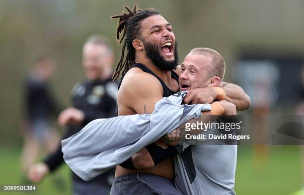 Lewis Ludlam celebrates with team mate Tom Cruse during the Northampton Saints training session held at Franklin's Gardens on March 20, 2024 in...