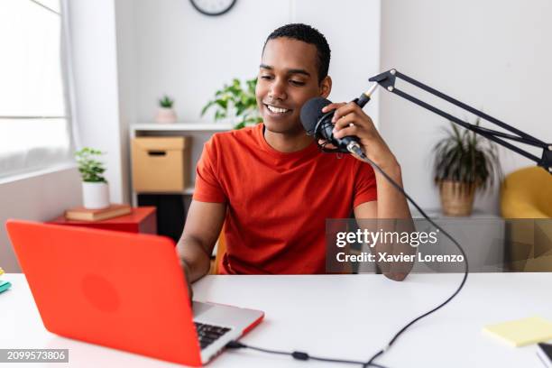 social media influencer man looking at laptop screen while recording video podcast. - entrepreneur stockfoto's en -beelden
