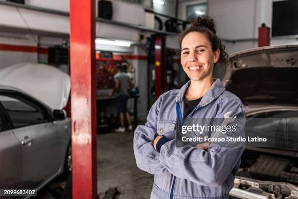 porträt eines assistenten mit schraubendreher in einer mechanischen werkstatt - automechaniker stock-fotos und bilder