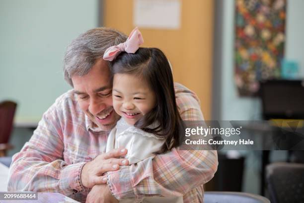 ダウン症の小学生の養女を抱きしめながら学校に通う父 - adopted chinese daughter ストックフォトと画像