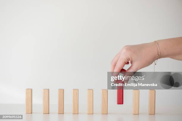 human hand stopping falling blocks on table - drop stop stock pictures, royalty-free photos & images
