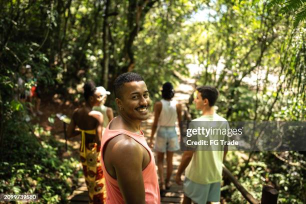 portrait of a young man hiking with friends on forest - ecoturismo imagens e fotografias de stock