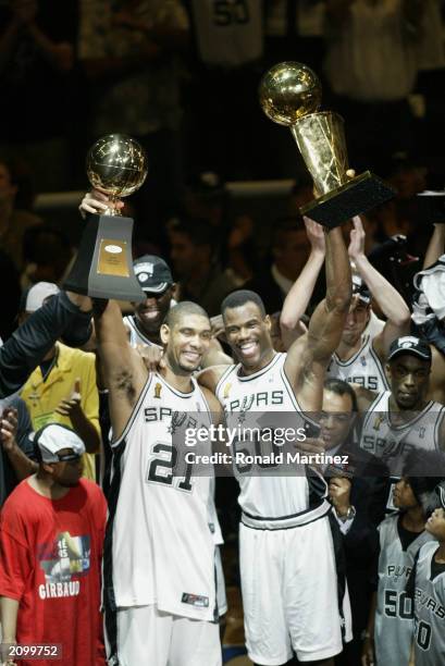 Tim Duncan of the San Antonio Spurs holds up his NBA Finals MVP award as teammate David Robinson holds up the 2003 NBA Championship trophy as the San...