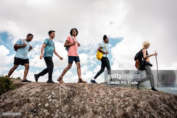 young friends doing a trail on a mountain - eco tourism stock pictures, royalty-free photos & images