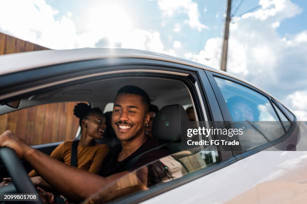 young man driving a car during a friends trip - driving stock pictures, royalty-free photos & images