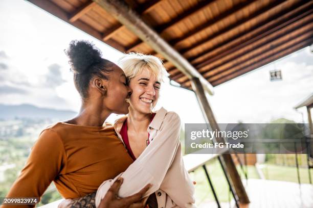 young homosexual couple embracing on balcony - love you stock pictures, royalty-free photos & images