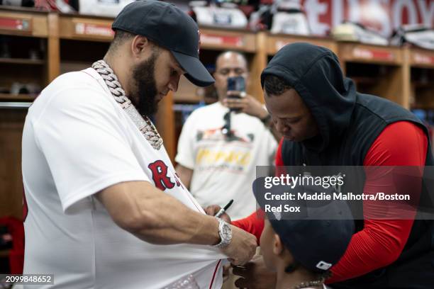 Rafael Devers of the Boston Red Sox signs the jersey of El Alfa in the clubhouse before a 2024 Dominican Republic Series game against the Tampa Bay...