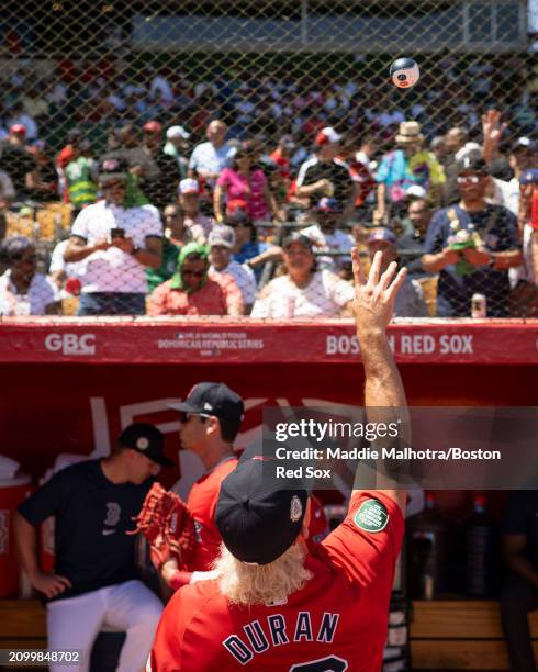 Jarren Duran of the Boston Red Sox tosses a ball to fans from the dugout before a 2024 Dominican Republic Series game against the Tampa Bay Rays as...