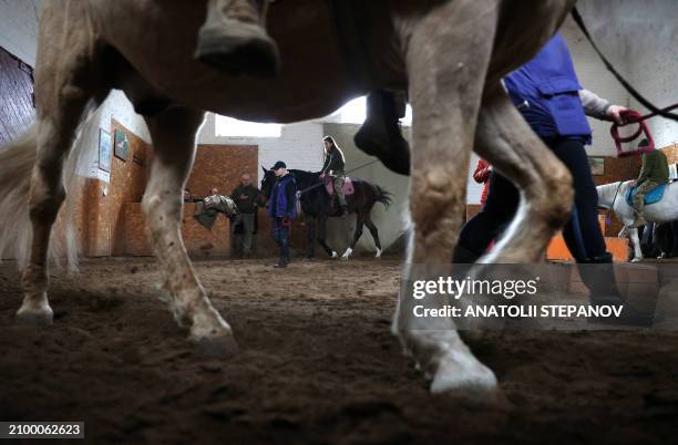 Ukrainian soldiers ride horses during a hippotherapy session at the "Spirit" rehabilitation centre in Kyiv, on March 22 amid the Russian invasion of...