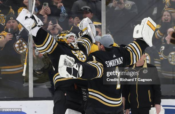 Linus Ullmark of the Boston Bruins celebrates a 6-2 win against the Ottawa Senators with teammate Jeremy Swayman at the TD Garden on March 19, 2024...