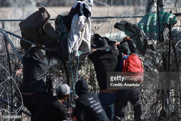 Irregular migrants try to cut with knives the razor wire fences put up by the Texas National Guard to make it more difficult for them to cross...