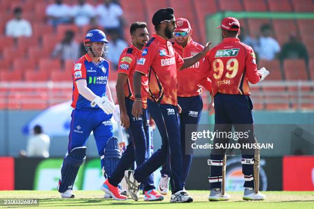 Punjab Kings' cricketers celebrate after the dismissal of Delhi Capitals' David Warner during the Indian Premier League Twenty20 cricket match...