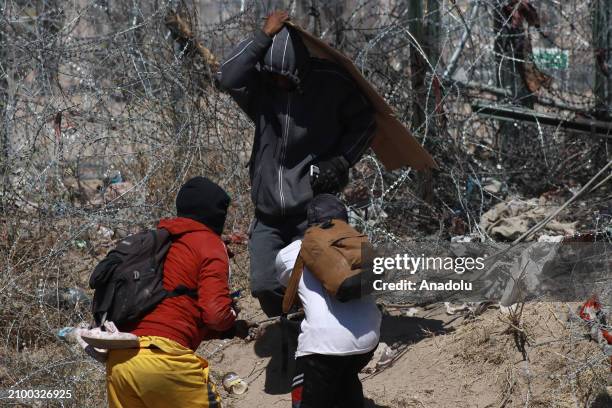 Irregular migrants try to cut with knives the razor wire fences put up by the Texas National Guard to make it more difficult for them to cross...